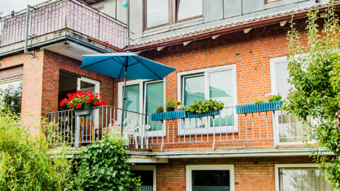 Bild zeigt einen grün bewachsenen Balkon eines Wohnhauses der Stiftung Drachensee.