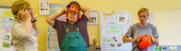 Bild zeigt Menschen beim Anprobieren von Gehörschutz