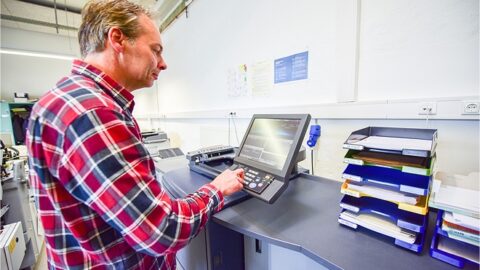 Bild zeigt Mensch an einer Maschine zum Drucken