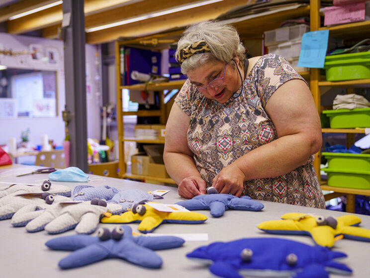 Bild zeigt Frau beim Arbeiten mit genähten Produkten