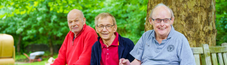 Bild zeigt drei Männer auf einer Bank