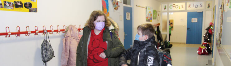 Bild zeigt ein Mädchen und einen Jungen auf dem Schulflur