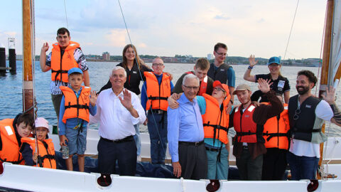 Bild zeigt eine Gruppe von Kindern, Jugendlichen und Erwachsenen auf einem Segelboot