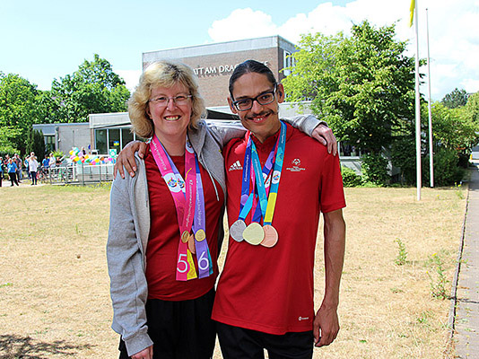 Bild zeigt zwei Personen mit Medaillen.